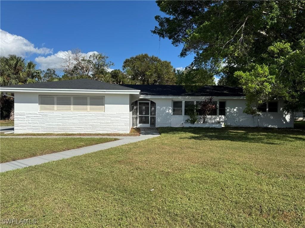 single story home with a front lawn