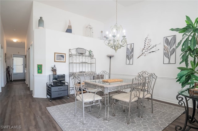 dining area with dark hardwood / wood-style flooring and a notable chandelier