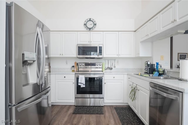 kitchen with stainless steel appliances, white cabinets, sink, dark hardwood / wood-style floors, and light stone countertops