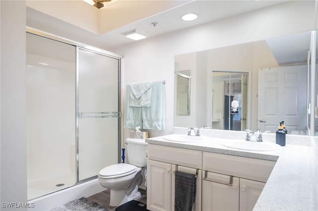 bathroom with toilet, vanity, and an enclosed shower