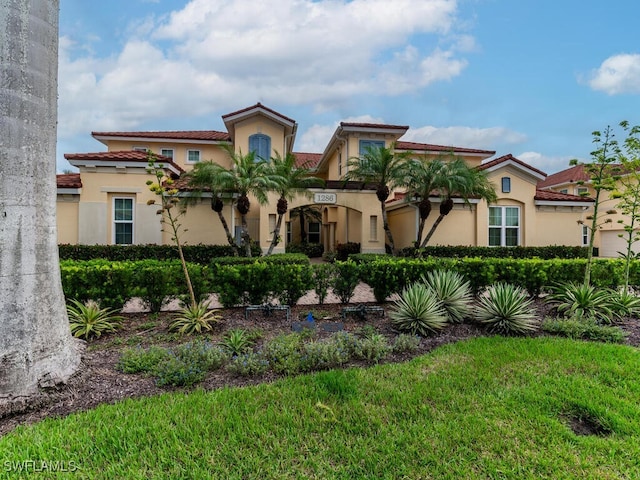 mediterranean / spanish house featuring a front lawn