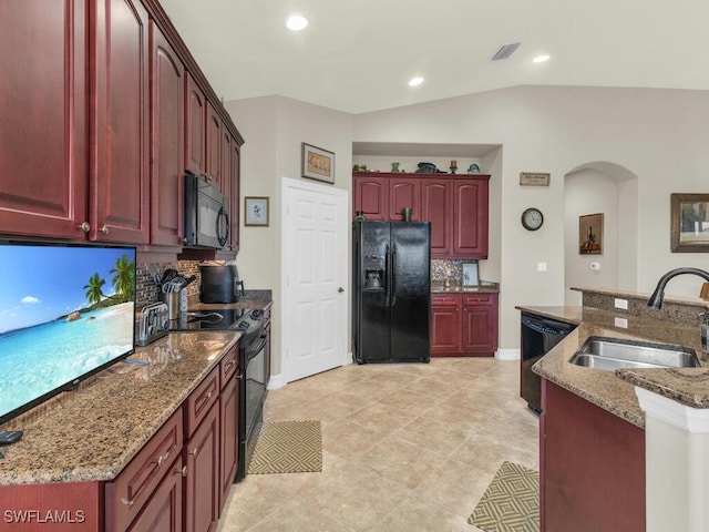 kitchen featuring tasteful backsplash, sink, black appliances, stone countertops, and lofted ceiling