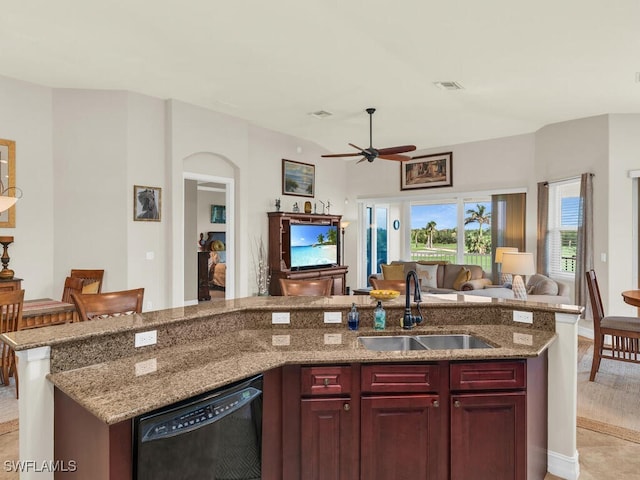 kitchen featuring light stone countertops, ceiling fan, sink, a center island with sink, and dishwasher