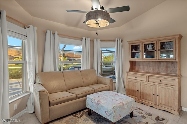 living room with ceiling fan, light tile patterned floors, and lofted ceiling