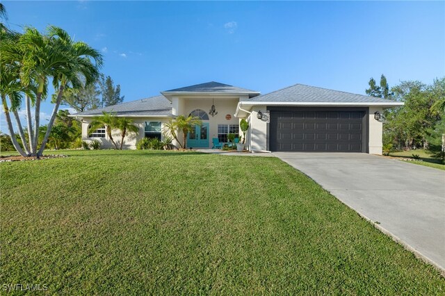 view of front of home with a garage and a front lawn