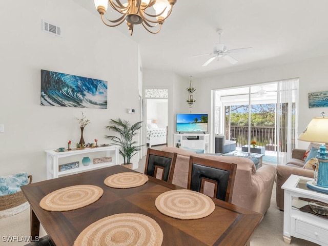 carpeted dining room featuring ceiling fan with notable chandelier