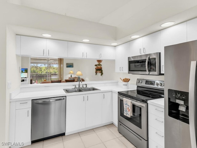 kitchen with light tile patterned flooring, white cabinetry, sink, and appliances with stainless steel finishes