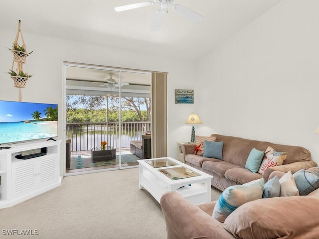 living room with carpet flooring, a water view, and ceiling fan