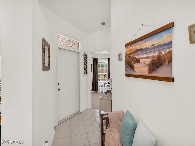 hallway with lofted ceiling and light tile patterned floors