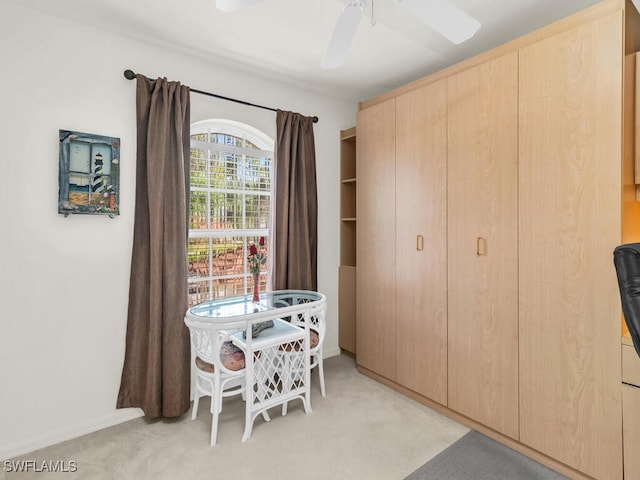 carpeted dining room with ceiling fan