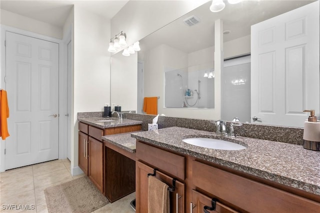 full bath with double vanity, visible vents, tile patterned flooring, a walk in shower, and a sink