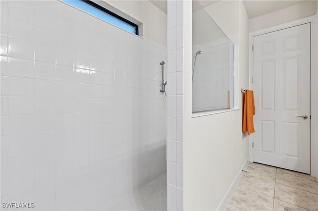 bathroom featuring tile patterned flooring, baseboards, and walk in shower