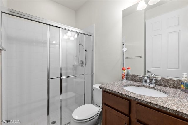 full bath with toilet, a stall shower, and vanity