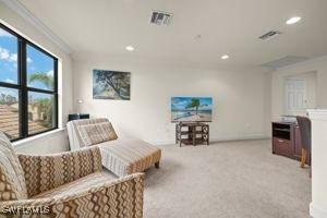 sitting room featuring ornamental molding, recessed lighting, visible vents, and light colored carpet