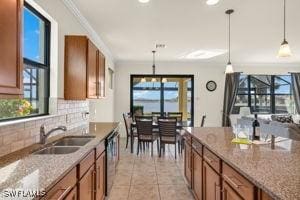 kitchen with stone counters, hanging light fixtures, and ornamental molding