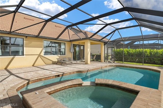 view of pool featuring glass enclosure, a patio area, and a pool with connected hot tub