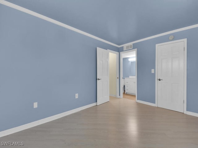 unfurnished room featuring ornamental molding and light wood-type flooring