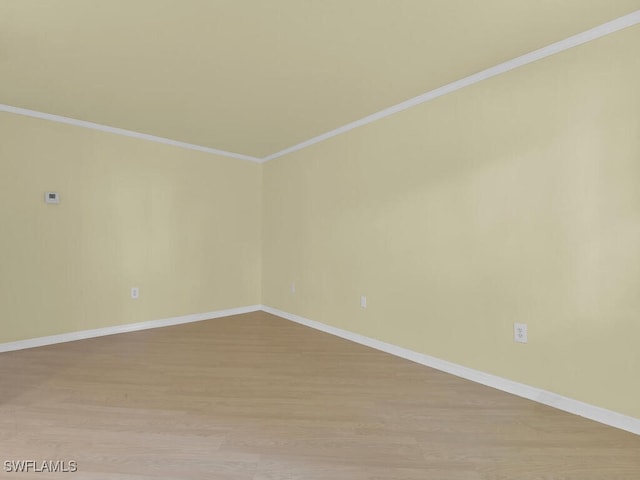 spare room with crown molding and light hardwood / wood-style flooring