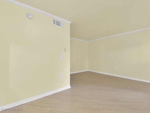 empty room with light wood-type flooring and ornamental molding