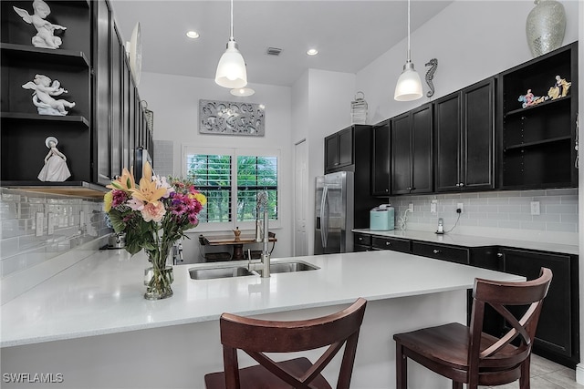 kitchen with stainless steel fridge, pendant lighting, a kitchen breakfast bar, and sink