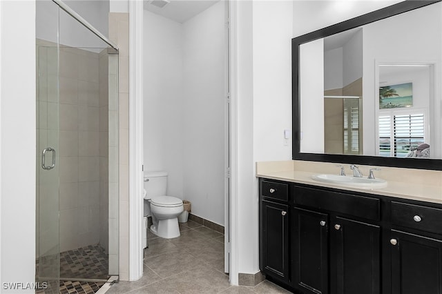 bathroom featuring tile patterned flooring, toilet, and a shower with shower door