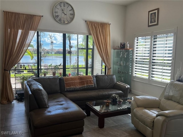 living room with tile patterned flooring and a water view