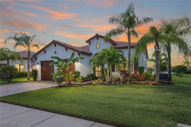 mediterranean / spanish-style home with a garage and a lawn