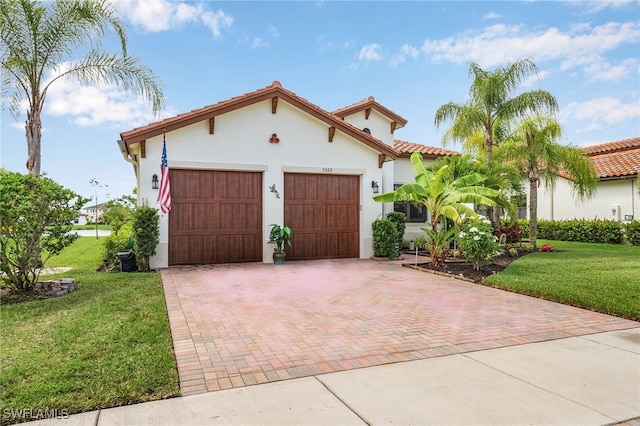 mediterranean / spanish-style home featuring a garage and a front yard