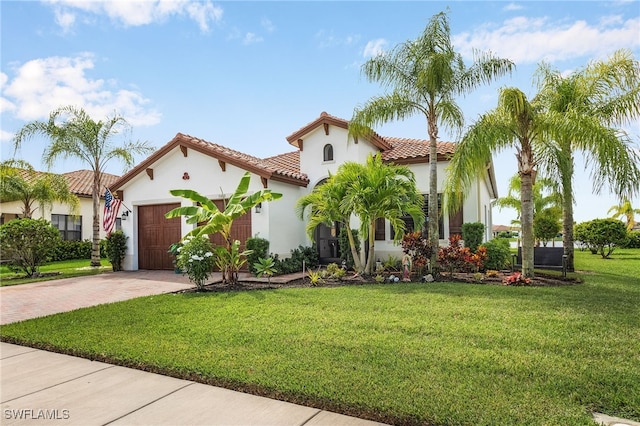 mediterranean / spanish house with a front lawn and a garage