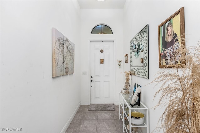 entryway featuring tile patterned flooring and a high ceiling