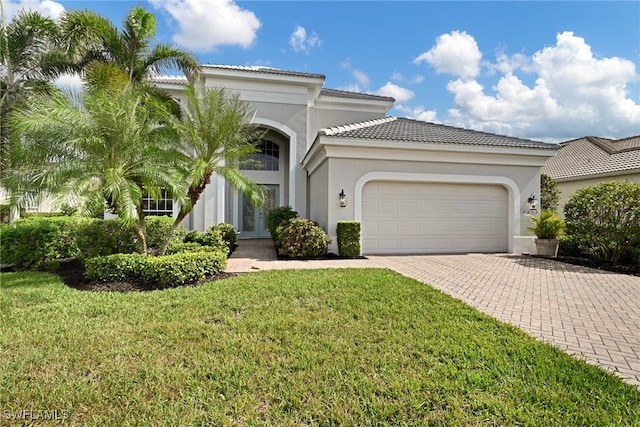 mediterranean / spanish home with a garage and a front yard