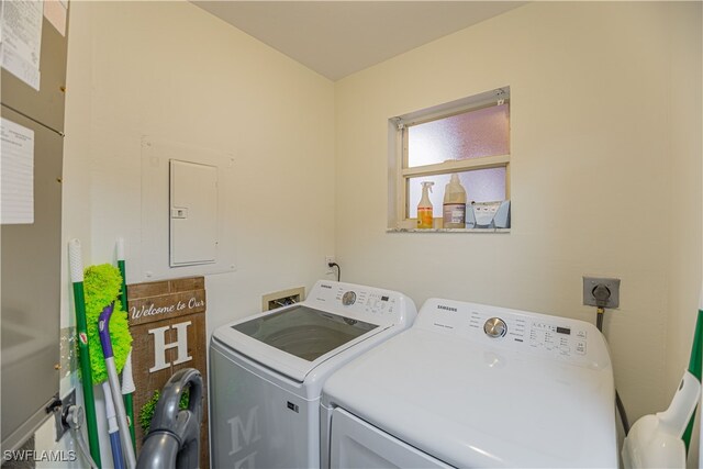 laundry area with electric panel and washing machine and clothes dryer