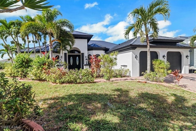 mediterranean / spanish-style house featuring a front yard and a garage