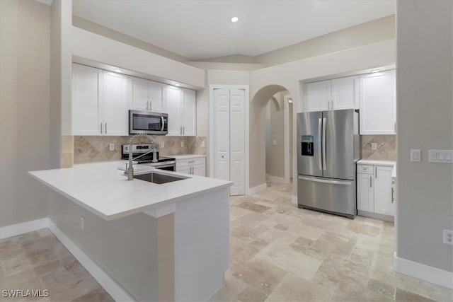 kitchen with white cabinets, decorative backsplash, and stainless steel appliances