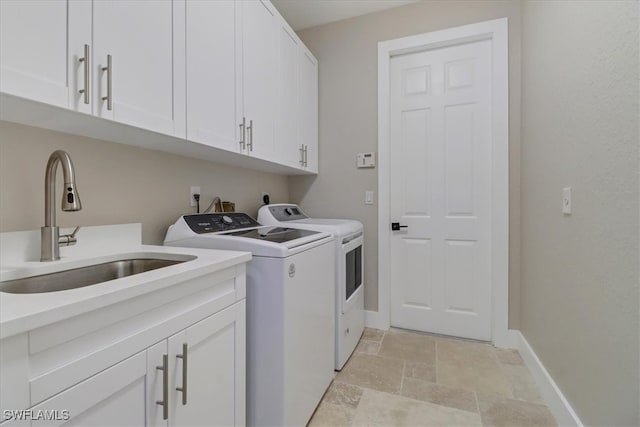 laundry room with washer and dryer, cabinets, and sink