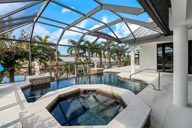 view of pool with a patio area, an in ground hot tub, and glass enclosure