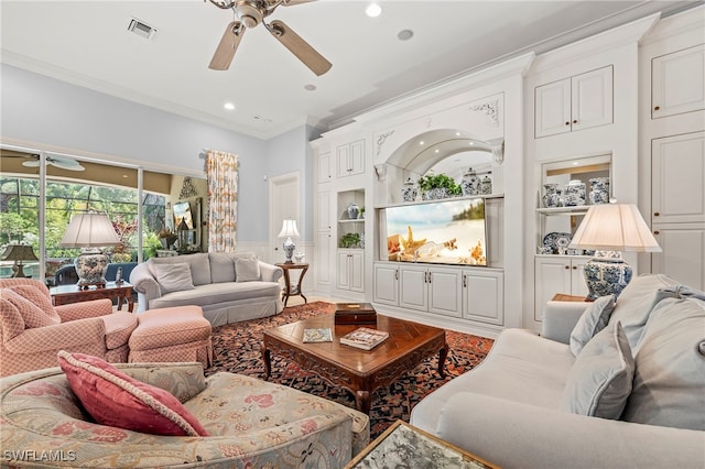 living room with ceiling fan, built in shelves, and ornamental molding