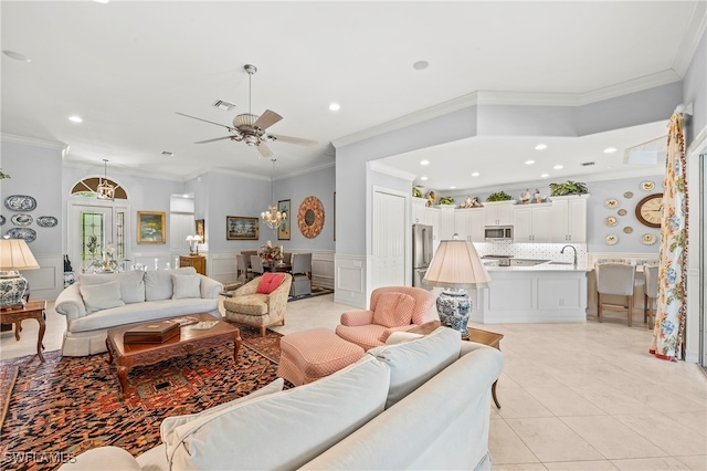 tiled living room featuring ceiling fan, sink, and crown molding