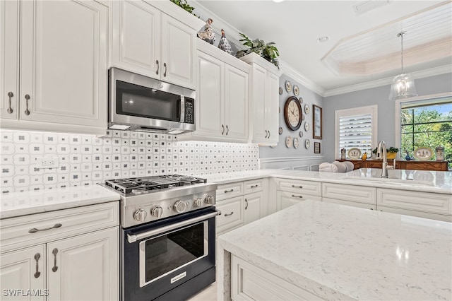 kitchen with stainless steel appliances, white cabinets, sink, and ornamental molding