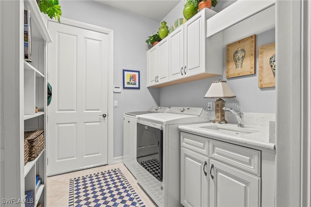 laundry room featuring cabinets, light tile patterned floors, washer and clothes dryer, and sink