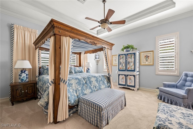 carpeted bedroom with a raised ceiling, ceiling fan, and crown molding