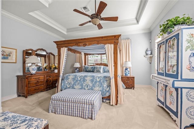 bedroom with light carpet, ceiling fan, and a tray ceiling