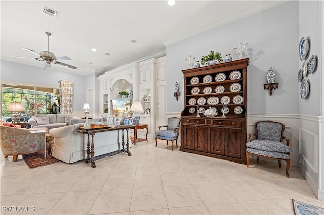 tiled living room featuring ceiling fan and crown molding