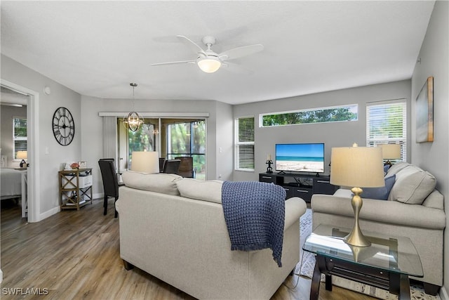 living room with wood-type flooring and ceiling fan with notable chandelier