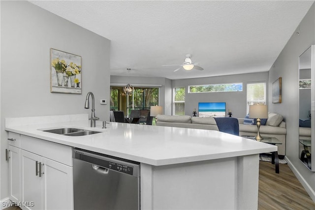 kitchen featuring sink, a textured ceiling, light hardwood / wood-style flooring, stainless steel dishwasher, and white cabinets