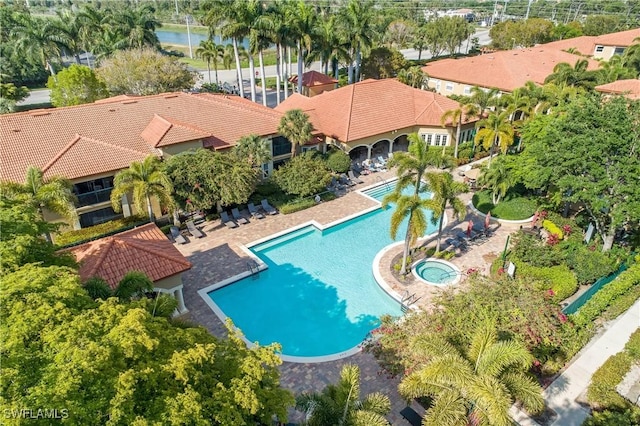 view of swimming pool featuring a hot tub and a patio area