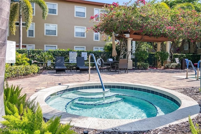 view of swimming pool featuring a hot tub, a pergola, and a patio area