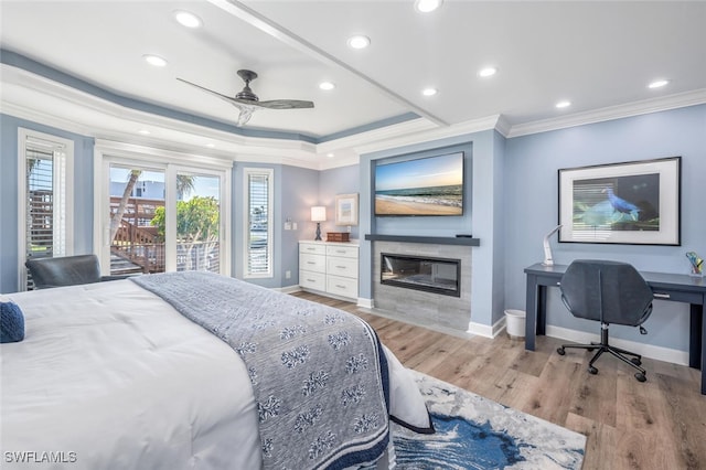 bedroom featuring access to exterior, ceiling fan, light hardwood / wood-style floors, a tiled fireplace, and ornamental molding