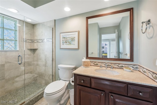 bathroom with vanity, toilet, and a shower with shower door