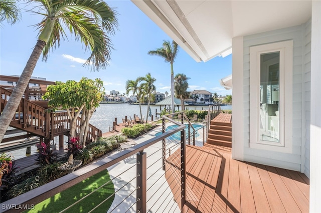 balcony with a water view and a dock